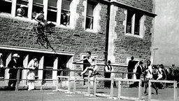 Doppelsieger im Hürdenlauf: Harry Hillman (USA/li.), beobachtet von Zuschauern aus ihren Fenstern in St. Louis © picture-alliance/ dpa 