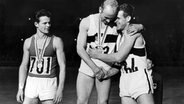 Zehnkampf-Olympiasieger Willi Holdorf (M.) bei der Siegerehrung in Tokio 1964 © picture alliance / dpa 