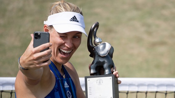Angelique Kerber macht ein Selfie mit der Siegertrophäe des Tennisturniers von Bad Homburg. © pciture alliance / dpa Foto: Sebastian Gollnow
