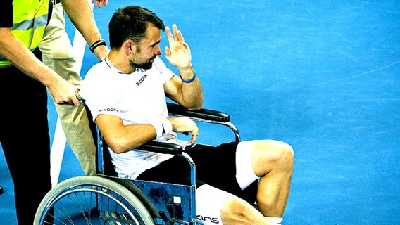 Tennis-Profi Nicolas Kiefer wird verletzt mit dem Rollstuhl vom Court gebracht. © dpa 
