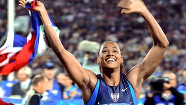 Die US-Amerikanerin Marion Jones jubelt mit der Landesfahne © picture-alliance / dpa