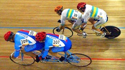 Der blinde Australier Ieran Modra (r.) und sein Pilot Short David übersprinten bei den Paralympics in Athen die Slowaken Juraj Petrovic (l.) und Vladislav Janovjak. Die Australier holen sich am 21.09.2004 Paralympics-Gold vor den Slowaken. Die blinden Radsportler fahren ihre Sprintrennen jeweils mit einem sehenden Piloten auf dem Tandem. © dpa - Sportreport 