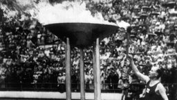 Die finnische Legende Paavo Nurmi entzündet 1952 in Helsinki das olympische Feuer. © picture-alliance / dpa