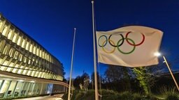 Die olympische Flagge weht am Eingang des Internationalen Olympischen Komitees © picture alliance/dpa/KEYSTONE Foto: Jean-Christophe Bott
