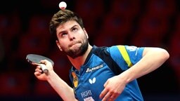 Tischtennisspieler Dimitrij Ovtcharov schaut bei der Angabe auf den Ball.