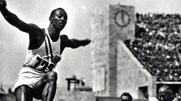 Weitspringer Jesse Owens (USA) bei seinem Sprung zur olympischen Goldmedaille 1936. © picture alliance / united archives