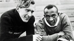 Der Deutsche Luz Long und der Amerikaner Jesse Owens beobachten ihre Konkurrenten beim Weitsprung. © ullstein bild - ullstein bild 