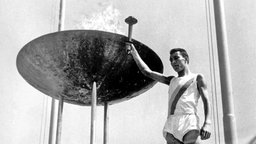 Giancarlo Peris entzündet 1960 in Rom das olympische Feuer. © picture-alliance / dpa