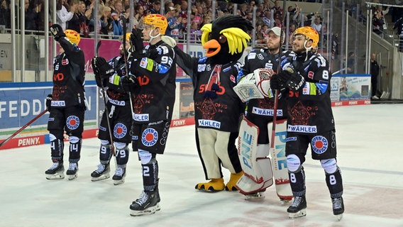 Die Eishockey-Profis der Fischtown Pinguins lassen sich mit ihrem Maskottchen von den Fans feiern. © picture alliance / kolbert-press Foto: Burghard Schreyer
