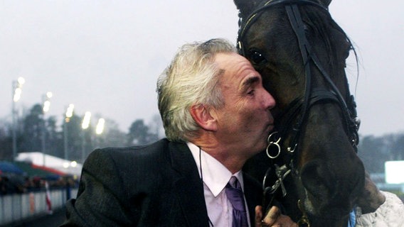 Alwin Schockemöhle küsst im Januar 2003 sein Pferd Abano As, das mit dem Belgier Jos Verbeek im Sulky den 81. Prix d'Amerique beim Trabrennen in Paris-Vincennes gewonnen hat. © picture-alliance / dpa/dpaweb 