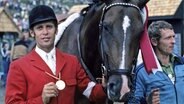 Alwin Schockemöhle (l.) zeigt 1976 in Montreal seine Goldmedaille und steht neben seinem Pferd Warwick © IMAGO / Horstmüller 