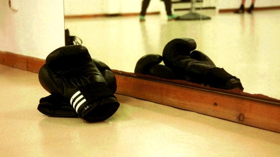Boxhandschuhe liegen auf dem Boden.  