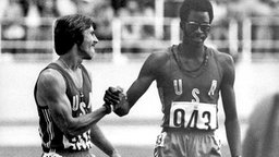 USA-Athlet Edwin Moses (r) empfängt im Ziel die Glückwünsche seines Landsmannes Michael Shine. © picture-alliance / dpa