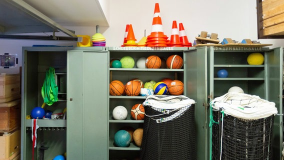 Bälle verschiedener Sportarten in einem Schrank. © IMAGO / Jürgen Schwarz 