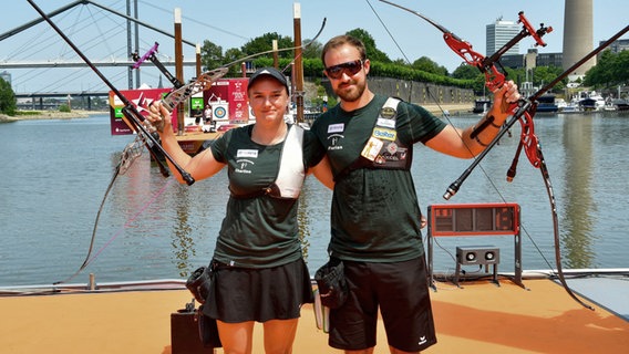 Florian Unruh und Charline Schwarz vom SSC Fockbek posieren nach dem Sieg bei den Finals gemeinsam mit ihren Bögen. © Deutscher Schützenbund e.V. Foto: Eckhard Frerichs