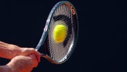 Ein Tennisschläger trifft den Ball am Hamburger Rothenbaum. © imago images / Tischler 