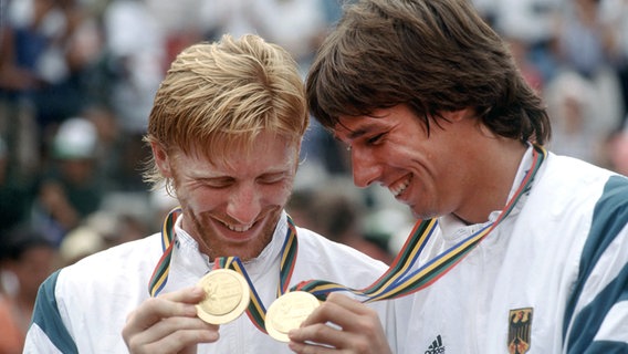 Boris Becker (l.) und Michael Stich schauen 1992 auf ihr Olympia-Gold. © Imago Images 
