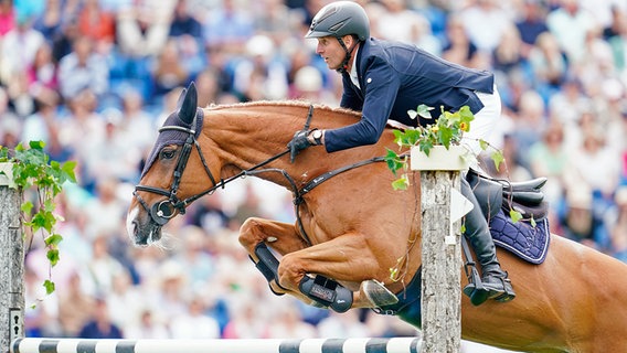 Der deutsche Reiter Andre Thieme auf dem Pferd Chakaria springt über ein Hindernis. © picture alliance/dpa 