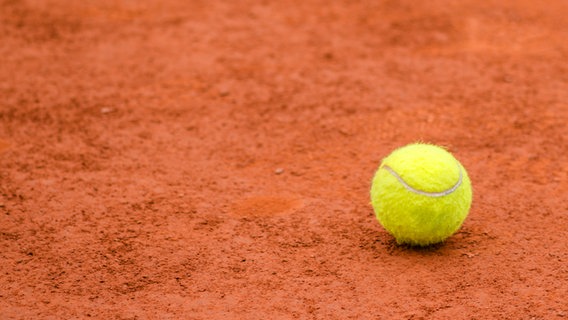 Auf Asche: Ein Ball liegt auf einem Tennisplatz. © istockphoto/tucko019 