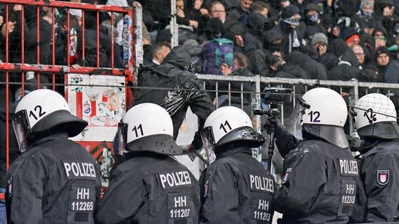 Einsatzkräfte der Hamburger Polizei stehen vor einem Fanblock im Millerntorstadion des FC St. Pauli © IMAGO / Jan Huebner 