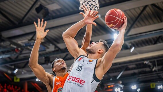 Vechtas Richmond Aririguzoh (l.) versucht Bambergs Filip Stanic von einem Korbwurf abzuhalten. © IMAGO / Christian Becker 