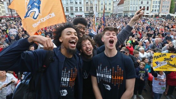 Die Spieler der Rostock Seawolves feiern mit ihren Fans vor dem Rathaus in Rostock ihren Aufstieg. © picture alliance/dpa Foto: Danny Gohlke