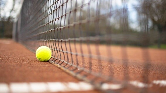 Ein Tennisball liegt an einem Tennisnetz. © IMAGO / photothek 