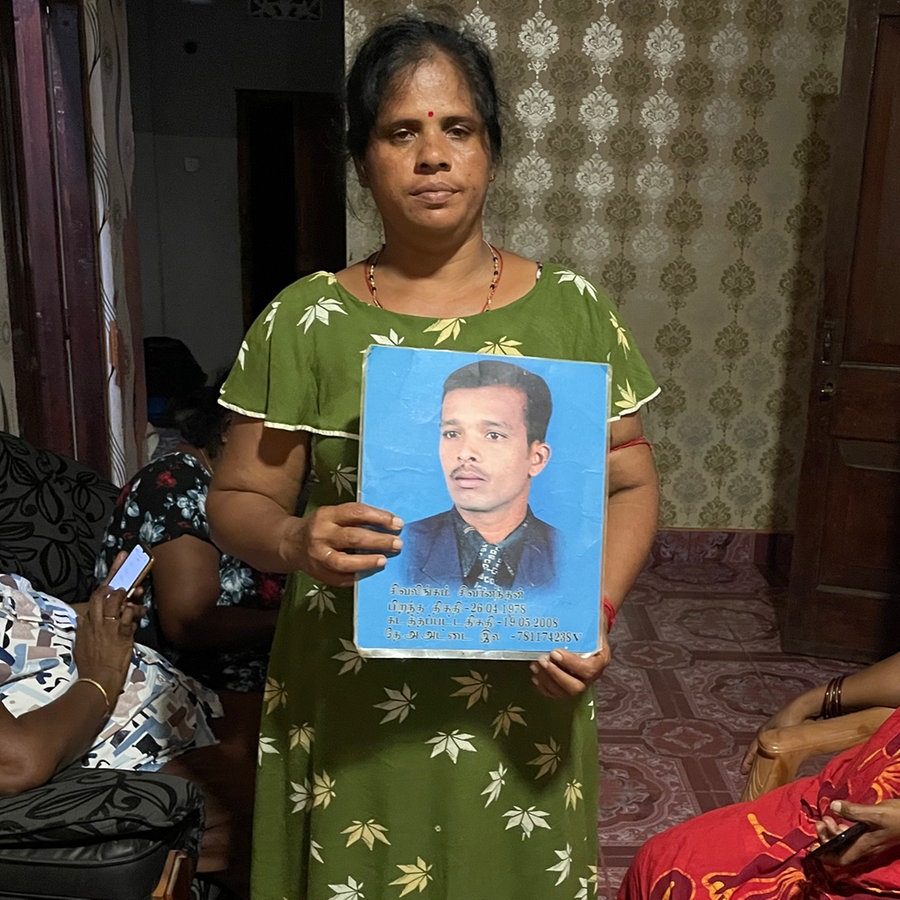 Eine Frau in Sri Lanka hält das Bild ihres vermissten Ehemanns hoch. © NDR Foto: Charlotte Horn