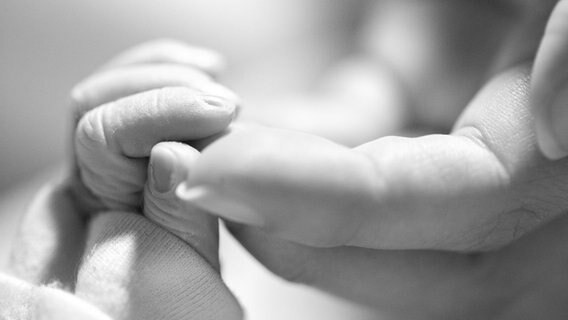 Eine Erwachsene hält die Hand eines verstorbenen Babys, eines Sternenkinds. © Dein Sternenkind Foto: Dein Sternkind