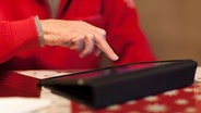 Ein alter Mann berührt seinen Tablet-Computer mit dem Mittelfinger. © dpa picture alliance Foto: Maximilian Schönherr