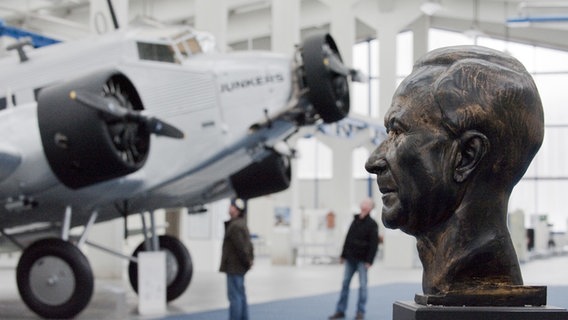 Die JU-52 und eine Statue des Flugzeugbauers Hugo Junkers (1859-1935) im Technikmuseum in Dessau-Roßlau. © dpa Foto: Peter Endig