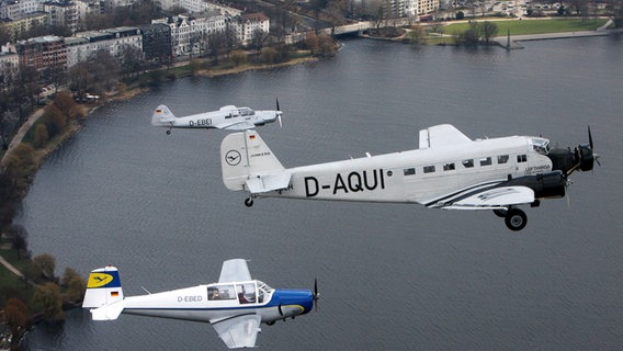 Die Junkers Ju 52 der Lufthansa (M) fliegt 2006 über Hamburg gemeinsam mit Traditionsflugzeugen der Lufthansa - Messerschmidt Me 108 Taifun (oben) und einer Saab Safir - eine Formation. © dpa Foto: Maurizio Gambarini