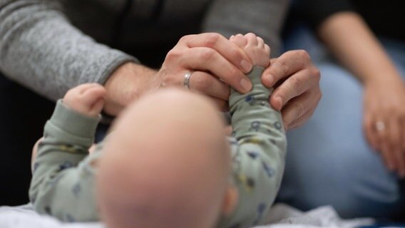 Ein Vater hält die Hand seines Kindes © picture alliance/dpa | Marijan Murat Foto: Marijan Murat