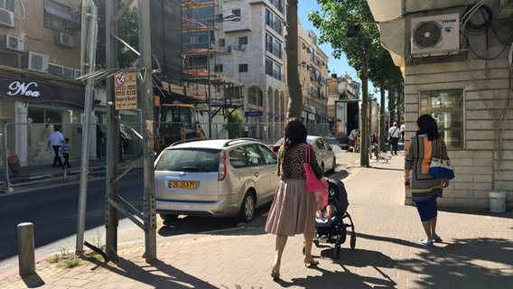 Eine Straße mit Auto und zwei Frauen in Tel Aviv. © ARD 