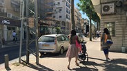 Eine Straße mit Auto und zwei Frauen in Tel Aviv. © ARD 