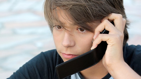 Ein Junge telefoniert mit erster Miene. © fotolia.com Foto: Eleonore H