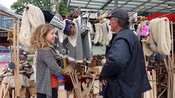 Eine junge Frau unterhält sich mit einem Händler auf einem Markt im bosnischen Banja Luka. © NDR Foto: Maja Bahtijarevic
