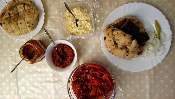 Verschiedene Gerichte und rote Pasten sind auf einem Tisch gedeckt. © NDR Foto: Maja Bahtijarevic