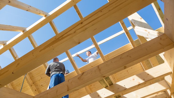 Zwei Männer arbeiten im Dachstock eines Holzhauses. © Colourbox Panthermedia Foto: -