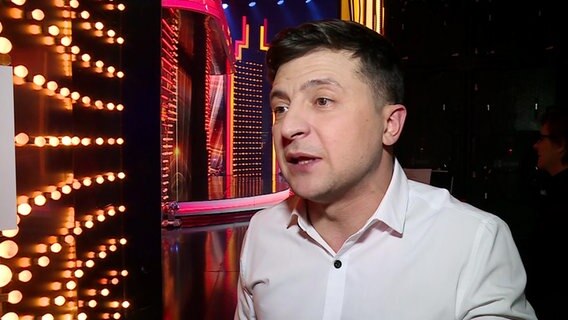 Der Schaupieler und Komiker Wolodimir Selenskij kandidiert für das Amt des Präsidenten der Ukraine - kein Scherz. Der 41-Jährige hat kurze dunkle Haare und trägt während des Interviews in einem TV-Studio ein Hemd. © NDR Foto: Screenshot