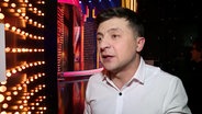 Der Schaupieler und Komiker Wolodimir Selenskij kandidiert für das Amt des Präsidenten der Ukraine - kein Scherz. Der 41-Jährige hat kurze dunkle Haare und trägt während des Interviews in einem TV-Studio ein Hemd. © NDR Foto: Screenshot