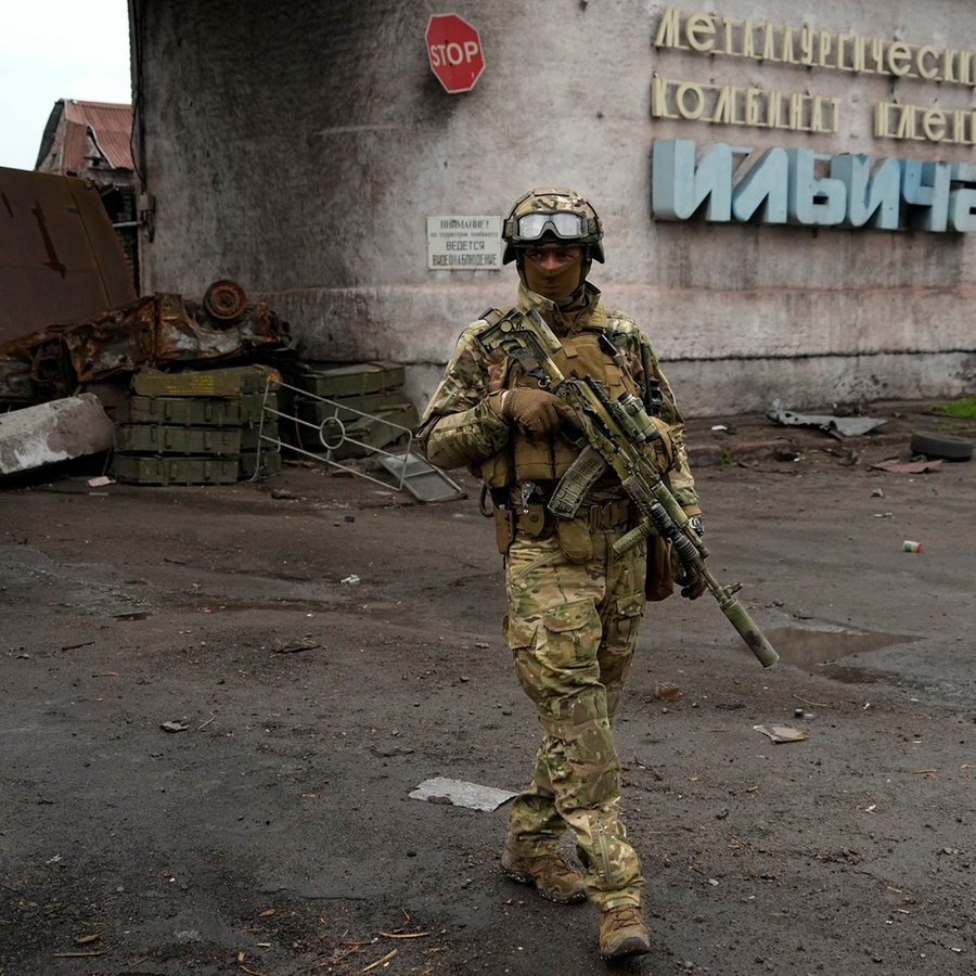 Ein russischer Soldat patrouilliert durch einen zerstörten Bereich des Iljitsch Eisen- und Stahlwerks Mariupol. © AP/dpa 