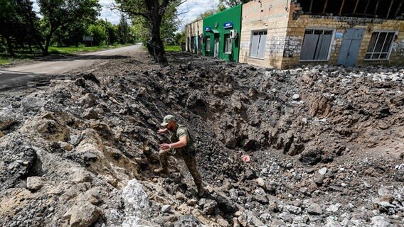 Ein ukrainischer Aufklärungssoldat steigt aus einem großen Bombenkrater in der Region Donbass. © ZUMA Press Wire/dpa Foto: Daniel Ceng Shou-Yi