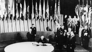 US-Praesident Harry S. Truman verfolgt 26. Juni 1945 die Unterzeichnung der "Charta der Vereinten Nationen" durch den Leiter der US-Delegation Edward R.Stettinius. © picture-alliance / akg-images 
