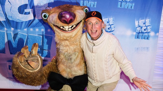 Otto Waalkes steht bei der Premiere zu Ice Age auf dem roten Teppich neben Sid dem Faultier. © Eventpress Herrman 