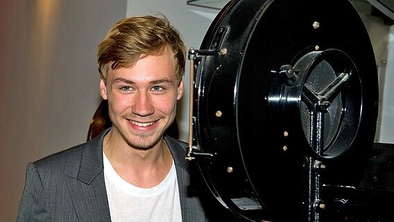 Der Schauspieler David Kross posiert am Donnerstag (03.11.2011) im Filmmuseum Potsdam zur Eröffnung der Ausstellung "Traumfabrik - 100 Jahre Film in Babelsberg" neben einem historischen Filmprojektor. © dpa Foto: Sören Stache