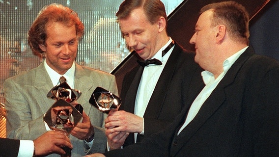 Die Schauspieler Jochen Horst, Ludger Pistor und Dieter Pfaff (v.l.n.r.) freuen sich über den Adolf-Grimme-Preis, den sie am 22.3.1996 in Marl für die RTL-Serie "Balko" erhalten hatten. © dpa-Fotoreport 