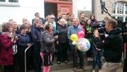 Eine Schulklasse und ein Bürgermeister mit Kamerateam  Foto: ndr.de