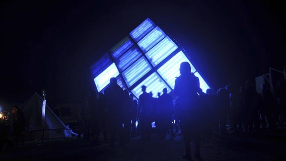 Ein von großer, innen blau leuchtender Würfel auf dem "Platz der Kosmonauten" der Fusion 2013. © imago/Frank Brexel 