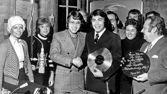 Frank Elstner (3.v.l.), Programmchef von Radio Luxemburg, gratuliert am 4. Dezember 1974 Roy Black zu dessen vierten Goldenen Schallplatte. © picture-alliance / dpa 